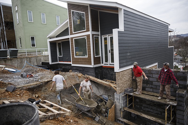 Workers install concrete outside GreenSpaces' first NextGen home on the North Shore on Thursday, Jan. 19, 2017, in Chattanooga, Tenn. Public tours of the home begin Jan. 22.