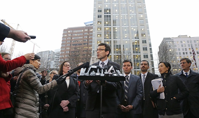 Washington Attorney General Bob Ferguson, center, talks to reporters Friday, Feb. 3, 2017, following a hearing in federal court in Seattle. A U.S. judge on Friday temporarily blocked President Donald Trump's ban on people from seven predominantly Muslim countries from entering the United States after Washington state and Minnesota urged a nationwide hold on the executive order that has launched legal battles across the country.(AP Photo/Ted S. Warren)