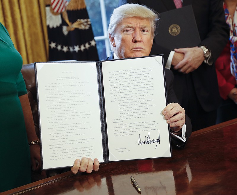 
              President Donald Trump holds up an executive order after his signing the order in the Oval Office of the White House in Washington, Friday, Feb. 3, 2017. The executive order that will direct the Treasury secretary to review the 2010 Dodd-Frank financial oversight law, which reshaped financial regulation after 2008-2009 crisis. (AP Photo/Pablo Martinez Monsivais)
            