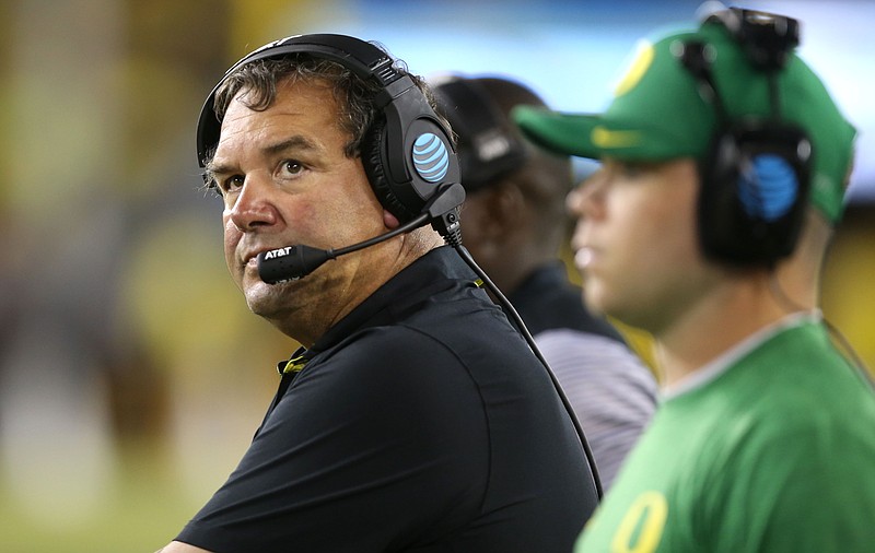 Oregon Defensive Coordinator Brady Hoke, left, keeps an eye on the clock in the closing moments of the NCAA college football game against Virginia Saturday, Sept. 10, 2016 in Eugene, Ore. (AP Photo/Chris Pietsch)