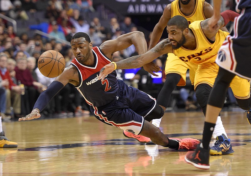 
              Washington Wizards guard John Wall, left, dives for a loose ball against Cleveland Cavaliers guard Kyrie Irving, right, during the first half of an NBA basketball game, Monday, Feb. 6, 2017, in Washington. (AP Photo/Nick Wass)
            