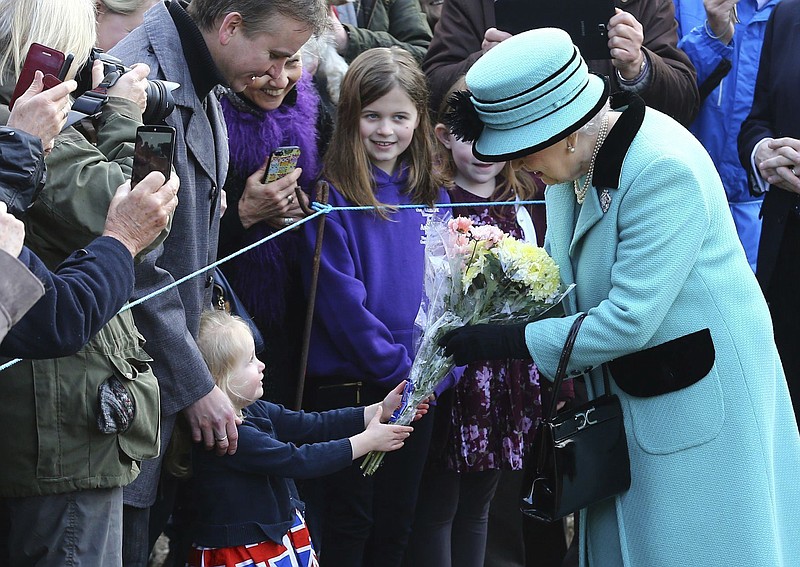 
              Britain's Queen Elizabeth II stops to receive flowers from 3-year old Jessica Atfield, after the queen and her husband Duke of Edinburgh, attended a church service at St Peter and St Paul church in West Newton, England, Sunday Feb. 5, 2017.  The Queen is to make history on Monday Feb. 6, when she becomes the first British monarch to reach the Sapphire Jubilee, marking the 65th. anniversary of her accession to the throne. (Gareth Fuller/PA via AP)
            