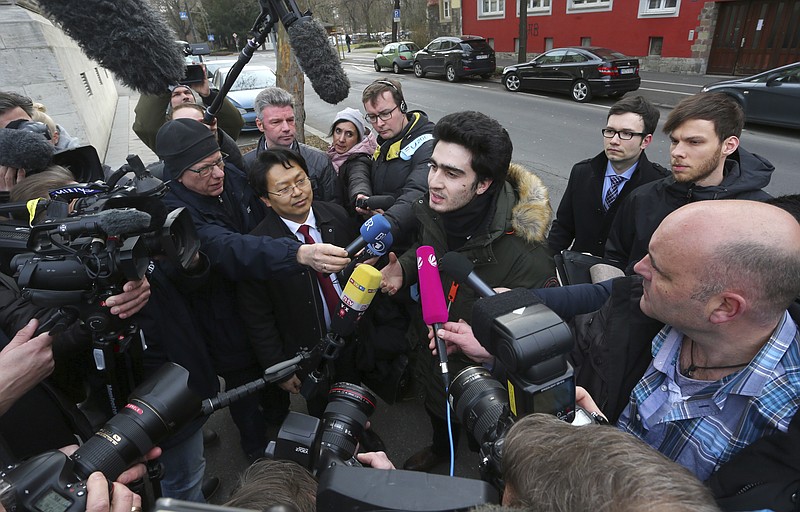 
              Anas Modamani,, center, arrives  at the regional court in Wuerzburg, Germany, Monday Feb. 6, 2017.  The Syrian refugee pictured in a 2015 selfie with German Chancellor Angela Merkel is seeking an injunction that would oblige Facebook to identify and delete posts on its site which wrongly link him to crimes committed by migrants.  ( Karl-Josef Hildenbrand/dpa via AP)
            