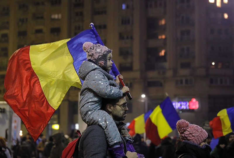 Young kid carries Romanian national flag during a demonstration in Bucharest, Romania, Sunday, Feb. 5, 2017. Romania's government met Sunday to repeal an emergency decree that decriminalizes official misconduct, a law that has prompted massive protests at home and widespread condemnation from abroad. (AP Photo/Vadim Ghirda)