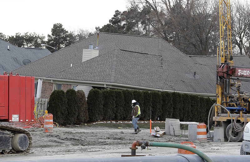 
              FILE - In this Jan. 4, 2017 file photo, a construction worker walks by a home collapsed by a sinkhole in Fraser, Mich. Water conservation efforts helped prevent bigger problems related a suburban Detroit sinkhole during the Super Bowl. (AP Photo/Carlos Osorio)
            