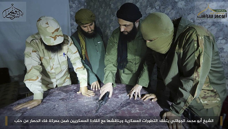 Abu Mohammed al-Golani, the leader of Fatah al-Sham Front, center, is seen in this picture posted by the group, discussing battlefield details with field commanders over a map. Syria's rebel groups and insurgents trying to oust President Bashar Assad have turned their guns on each other in some of the worst infighting yet, with al-Qaida-linked fighters battling other factions in a split between supporters and opponents of the Russian-led push for a new peace process for the country. (Militant UGC via AP, File )