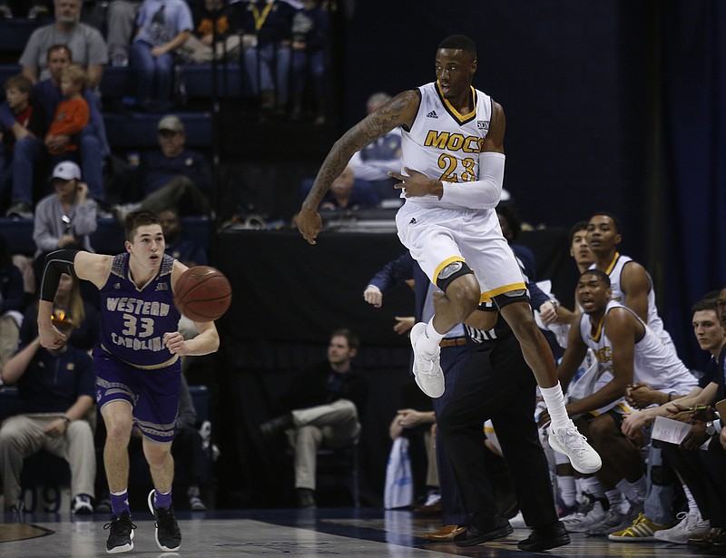 UTC forward Tre' McLean, right, leaps and saves the ball from going out of bounds near Western Carolina forward Onno Steger (33) during Saturday's game at McKenzie Arena.