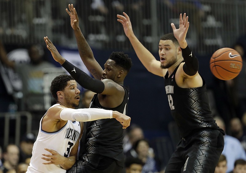 
              Villanova's Josh Hart, left, pass the ball around Georgetown's L.J. Peak, center, and Bradley Hayes during the first half of an NCAA college basketball game, Tuesday, Feb. 7, 2017, in Villanova, Pa. (AP Photo/Matt Slocum)
            