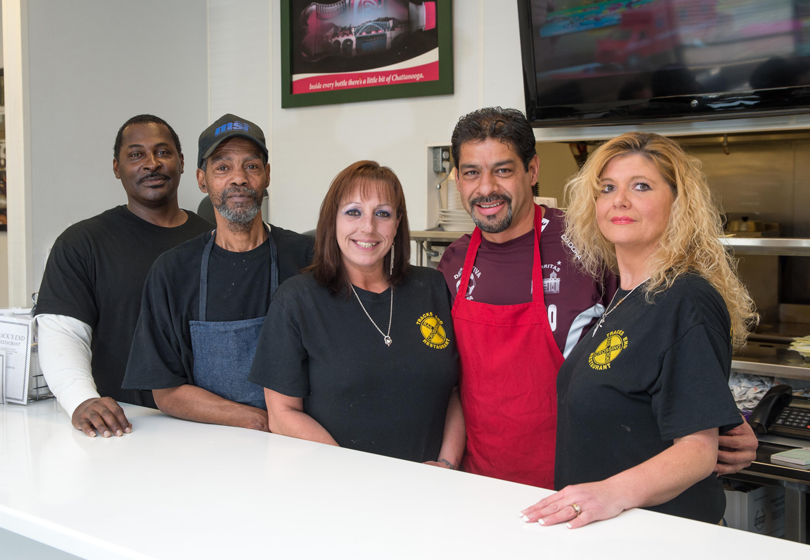 Jimmy Drake, Terry Kelly, Christy Shrader, Victor Rodriguez and Paula Silmon stand behind the counter at Track's End. (Photo by Mark Gilliland)