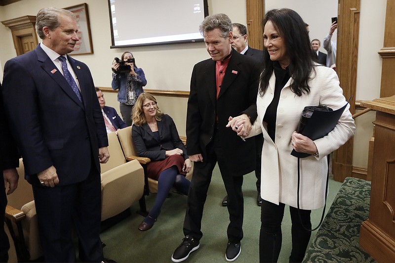 
              Country singer Randy Travis, center, walks into a hearing room with his wife, Mary, before a meeting of the Senate Health and Welfare Committee on Wednesday, Feb. 8, 2017, in Nashville, Tenn. Randy Travis, who suffered a stroke in 2013, attended the hearing for Stroke Awareness Day at the legislature. Dozens of country stars, from Garth Brooks to Kenny Rogers, are scheduled to perform at a tribute show Wednesday night in Nashville to honor Travis. At left is Sen. Bill Ketron, R-Murfreesboro. (AP Photo/Mark Humphrey)
            