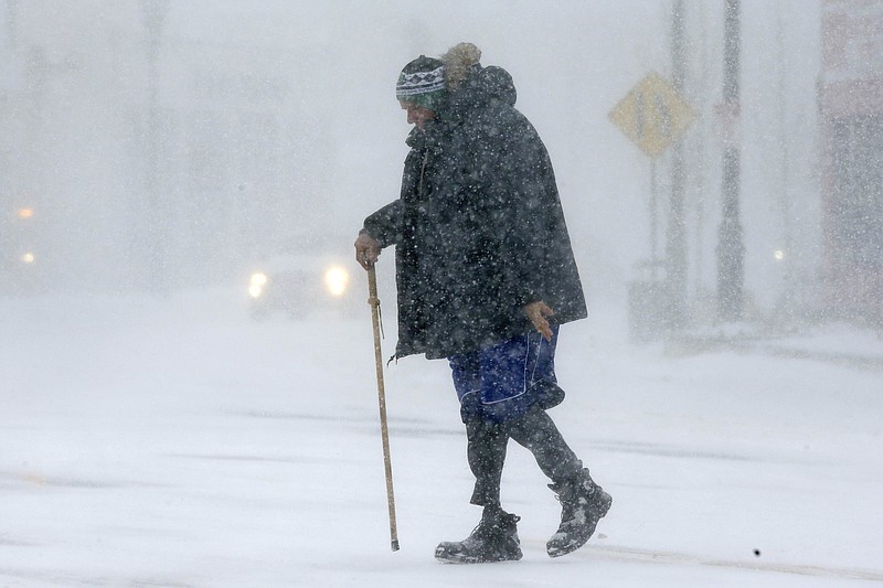 Todd Fike, crosses the street during a snowstorm, Thursday, Feb. 9, 2017, in Framingham, Mass. (AP Photo/Steven Senne)