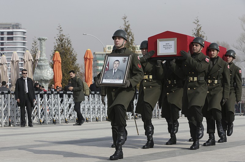 
              Military honour guard carry the coffin of Mahmut Uslu, one of five Turkish soldiers killed in an attack by IS militants around the Syrian town al Bab on Tuesday, during a ceremony in Ankara, Turkey, Thursday, Feb. 9, 2017. (AP Photo/Burhan Ozbilici)
            