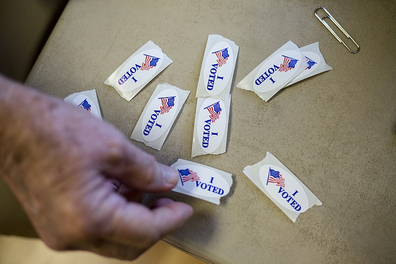 A poll worker sets out "I Voted" stickers on the first day of early voting at the North River Civic Center on Oct. 19, 2016, in Chattanooga.