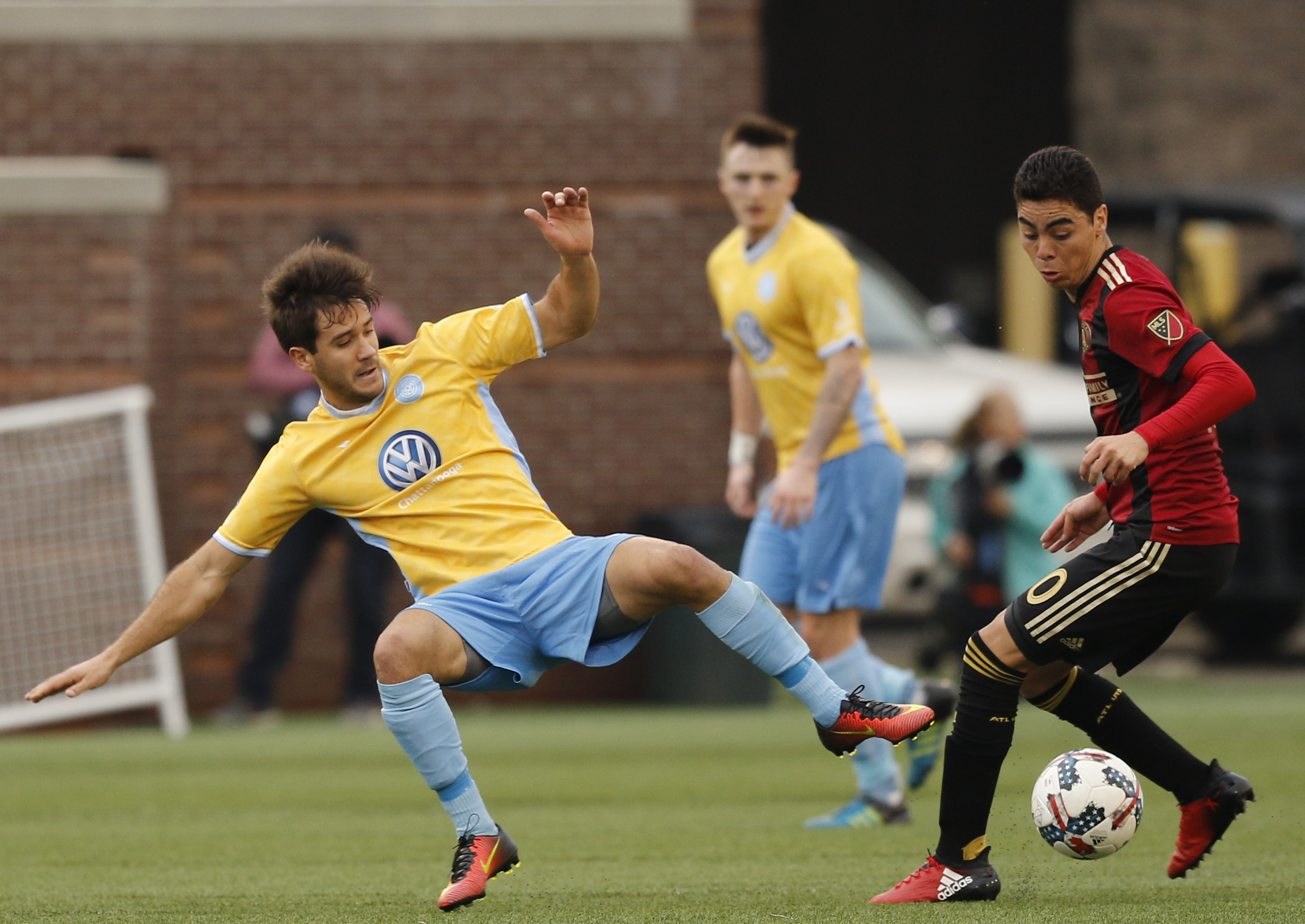 CFC's Zecca Ferraz, left, is tripped up by AUFC's Miguel Almiron during Chattanooga FC's friendly match against Atlanta United FC at Finely Stadium on Saturday, Feb. 11, 2017, in Chattanooga, Tenn.