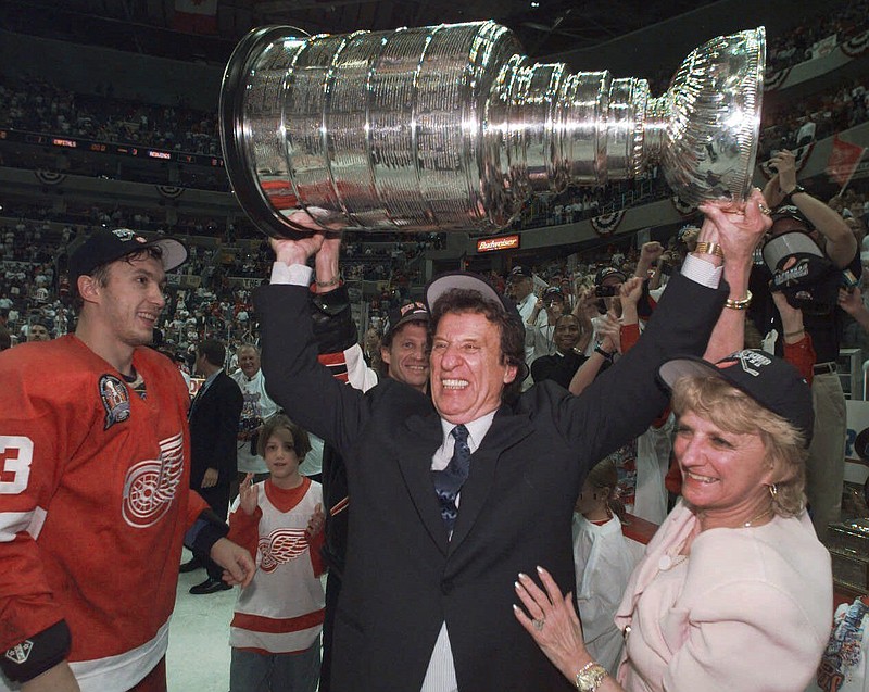 
              CORRECTS RED WINGS PLAYER TO VYACHESLAV KOZLOV, INSTEAD OF IGOR LARIONOV - FILE - In this June 17. 1998, file photo, Detroit Red Wings owner Mike Ilitch, center, hoists the Stanley Cup in Washington after the Red Wings won their second consecutive NHL championship. Vyacheslav Kozlov is at left. Ilitch, founder of the Little Caesars Pizza empire and owner of the Red Wings and the Detroit Tigers, has died. He was 87. Ilitch, who was praised for keeping his professional hockey and baseball teams in Detroit as other urban sports franchises relocated to new suburban stadiums, died Friday, Feb. 10, 2017, at a hospital in Detroit, according to family spokesman Doug Kuiper. (Julian H. Gonzalez/Detroit Free Press via AP)
            