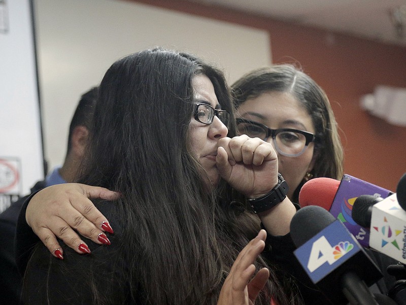 
              CLARIFIES THAT FATHER HAS NOT BEEN DEPORTED- Marlene Mosqueda, left, who's father was arrested by ICE early Friday morning to be deported, is comforted at a news conference by her attorney Karla Navarrette at The Coalition for Humane Immigrant Rights of Los Angeles (CHIRLA) on Friday, Feb. 10, 2017. Navarrete, said she sought to stop Mosqueda from being placed on a bus to Mexico and was told by ICE that things had changed. She said another lawyer filed federal court papers to halt his removal. (AP Photo/Nick Ut)
            