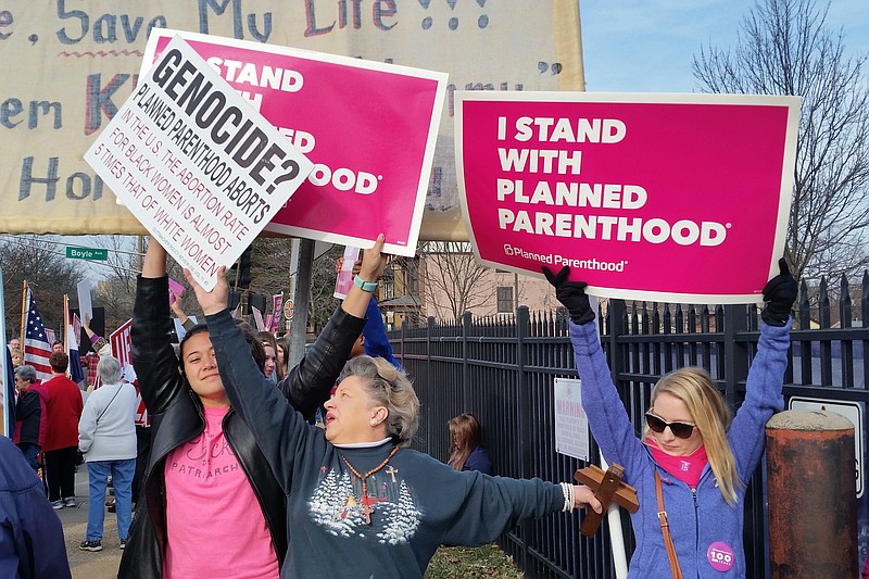 
              A Planned Parenthood supporter and opponent try to block each other's signs during a protest and counter-protest Saturday, Feb. 11, 2017 in St. Louis.   Rallies aimed at urging Congress and President Donald Trump to end federal funding for Planned Parenthood are scheduled across the country. (AP Photo/Jim Salter)
            
