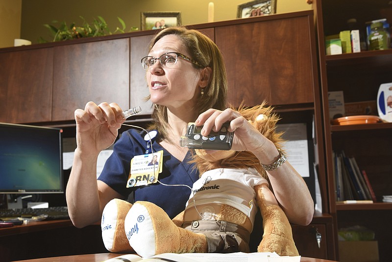 
              In this Wednesday, Jan. 11, 2017 photo, diabetes educator Kimberly P. Miller, BSN, RN, CDE, holds a Medtronic Minimed diabetes insulin pump in her office at CHI Memorial, in Chattanooga, Tenn. (Tim Barber/Chattanooga Times Free Press via AP)
            