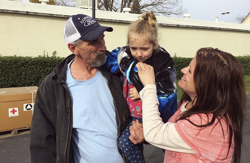 
              Oroville, Calif., resident Patrick Cumings, left, holds his daughter, Elizabeth, and he stands with his wife, Elizabeth Cumings at the Red Cross evacuation center in Chico, Calif., Monday, Feb. 13, 2017. The water level has dropped behind the Oroville Dam, nation's tallest dam, in Oroville reducing the risk of a catastrophic spillway collapse and easing fears that prompted the evacuation of the Cumings and others downstream. (AP Photo/Don Thompson)
            