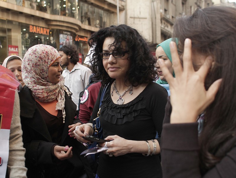 
              FILE - In this Thursday, March 8, 2012 file photo, Egyptian activist Samira Ibrahim, left, and Mona Eltahawy, a prominent Egyptian-born U.S. columnist, center, march in downtown Cairo, Egypt to mark International Women's Day. The Associated Press has found that the prominent American author is among dozens of activists, lawyers and human rights advocates who have been targeted in a sweeping cyberespionage campaign blamed on the Egyptian government. Booby-trapped emails sent to Eltahawy in December came from the same address behind the distribution of identical malicious messages to a host of other activists across Egypt.(AP Photo/Maya Alleruzzo, File)
            