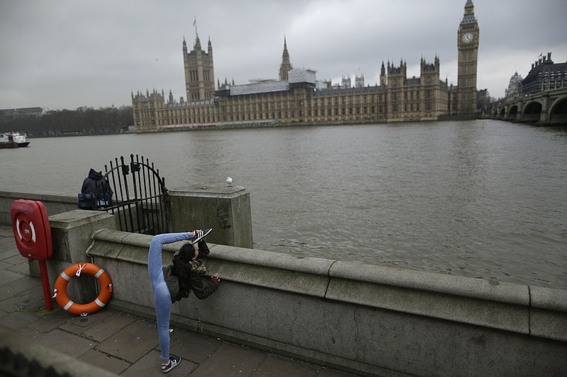 
              A youngster sightseeing with her family performs a gymnastic move on the south bank of the River Thames back dropped by the Houses of Parliament in London, Wednesday, Feb. 8, 2017. Britain's House of Commons is set to approve a bill authorizing the start of exit talks with the European Union — a major step on the road to Brexit. The bill sailed through an earlier vote last week 498-114 and is very likely to pass its final Commons test Wednesday evening. (AP Photo/Matt Dunham)
            