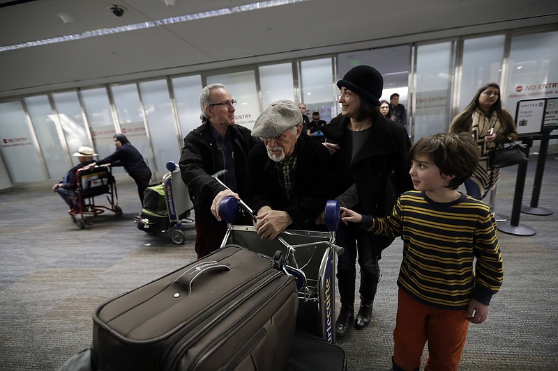 
              FILE - In this Saturday, Jan. 28, 2017, file photo, Abdollah Mostafavi, center, arriving from Tehran, Iran, is met by his family including son-in-law Nasser Sorkhavi, left, daughter Mozhgan Mostafavi, second from right, and grandson Kourosh Sorkhavi at San Francisco International Airport in San Francisco. Mostafavi was held at the airport for some time as a result of President Donald Trump's executive order. A federal judge has granted a preliminary injunction barring the Trump administration from implementing its travel ban in Virginia. A federal appeals court in California has already upheld a national temporary restraining order stopping the government from implementing the ban. (AP Photo/Marcio Jose Sanchez, File)
            