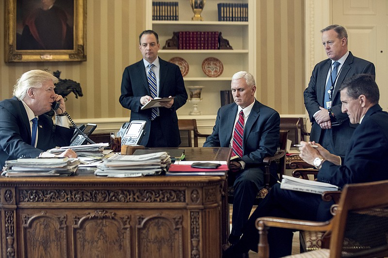 In this Jan. 28, 2017, file photo, President Donald Trump accompanied by, from second from left, Chief of Staff Reince Priebus, Vice President Mike Pence, White House press secretary Sean Spicer and National Security Adviser Michael Flynn speaks on the phone with Russian President Vladimir Putin in the Oval Office at the White House in Washington. Flynn resigned as President Donald Trump's national security adviser Monday, Feb. 13, 2017. (AP Photo/Andrew Harnik, File)