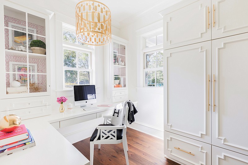 Florida-based interior designer Laura Burleson used gold-tone metal hardware, accessories and lighting to bring a warm glow to this home office, then added a cozy throw blanket and flowers to make this practical space feel brighter and more cheerful at any time of year.