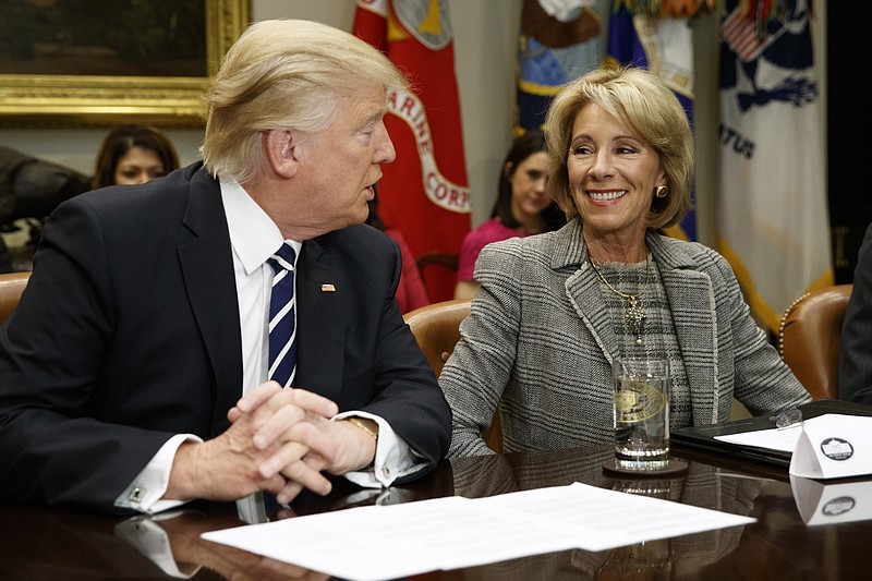 
              President Donald Trump looks at Education Secretary Betsy DeVos as he speaks during a meeting with parents and teachers, Tuesday, Feb. 14, 2017, in the Roosevelt Room of the White House in Washington. (AP Photo/Evan Vucci)
            