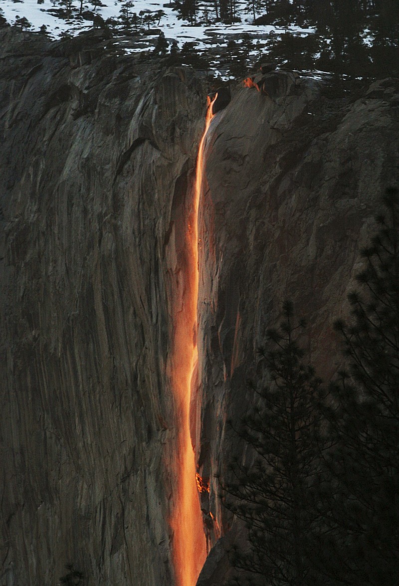 
              FILE - In this Feb. 16, 2010, file photo, a shaft of sunlight creates a glow near Horsetail Fall, in Yosemite National Park, Calif. Mother Nature is again putting on a show at California’s Yosemite National Park, where every February the setting sun draws a narrow sliver on a waterfall to make it glow like a cascade of molten lava. The phenomenon known as “firefall” draws scores of photographers to the spot, which flows down the granite face of the park’s famed rock formation, El Capitan. (Eric Paul Zamora/The Fresno Bee via AP, File)
            