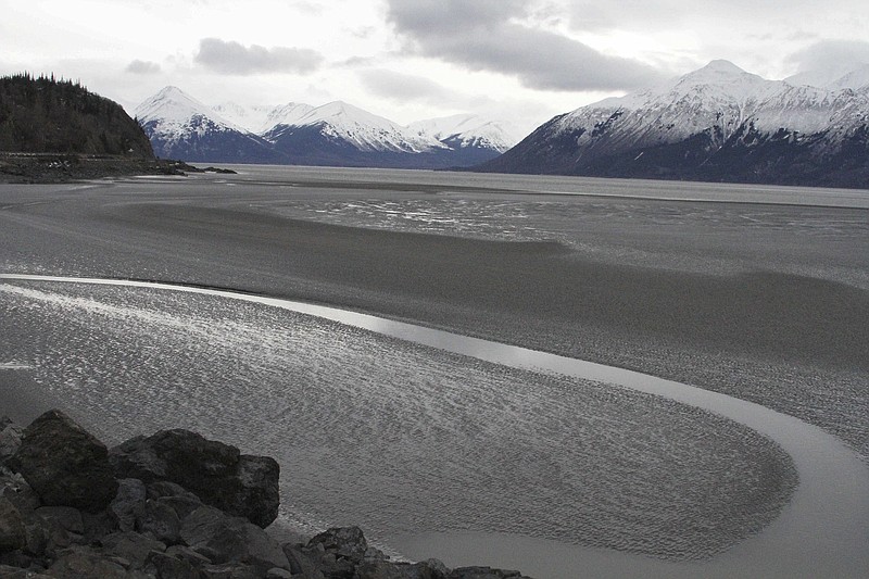 
              FILE - In this March 7, 2016, file photo, a ribbon of water cuts through the mud flats of Cook Inlet, just off the shore of Anchorage, Alaska. Natural gas is bubbling up from an underwater pipeline in Alaska's Cook Inlet, discovered on Feb 7, 2017, when a Hilcorp helicopter spotted bubbles at the surface and reported the leak. State regulators say the danger is minimal but the Coast Guard has issued a warning to mariners and federal wildlife authorities have expressed concern about harm to endangered beluga whales. (AP Photo/Mark Thiessen, File)
            