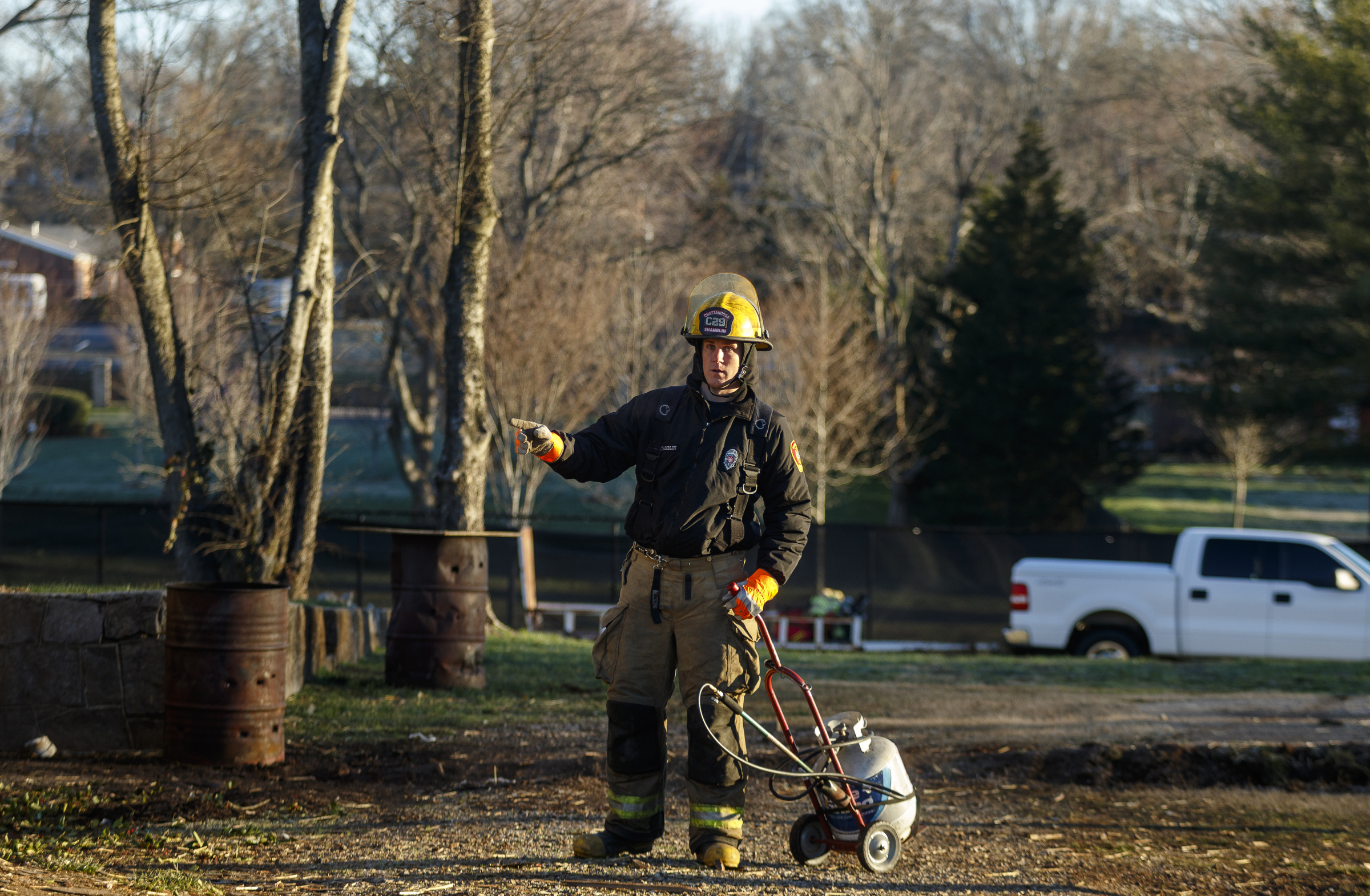 A firefighter moves a propane tank for lighting tinder before burning down a structure at a live burn training event by the Chattanooga Fire Department on Robin Drive on Thursday, Feb. 16, 2017, in Chattanooga, Tenn. The fire department uses live burns as part of their fire academy training, culminating in the complete immolation of a structure.