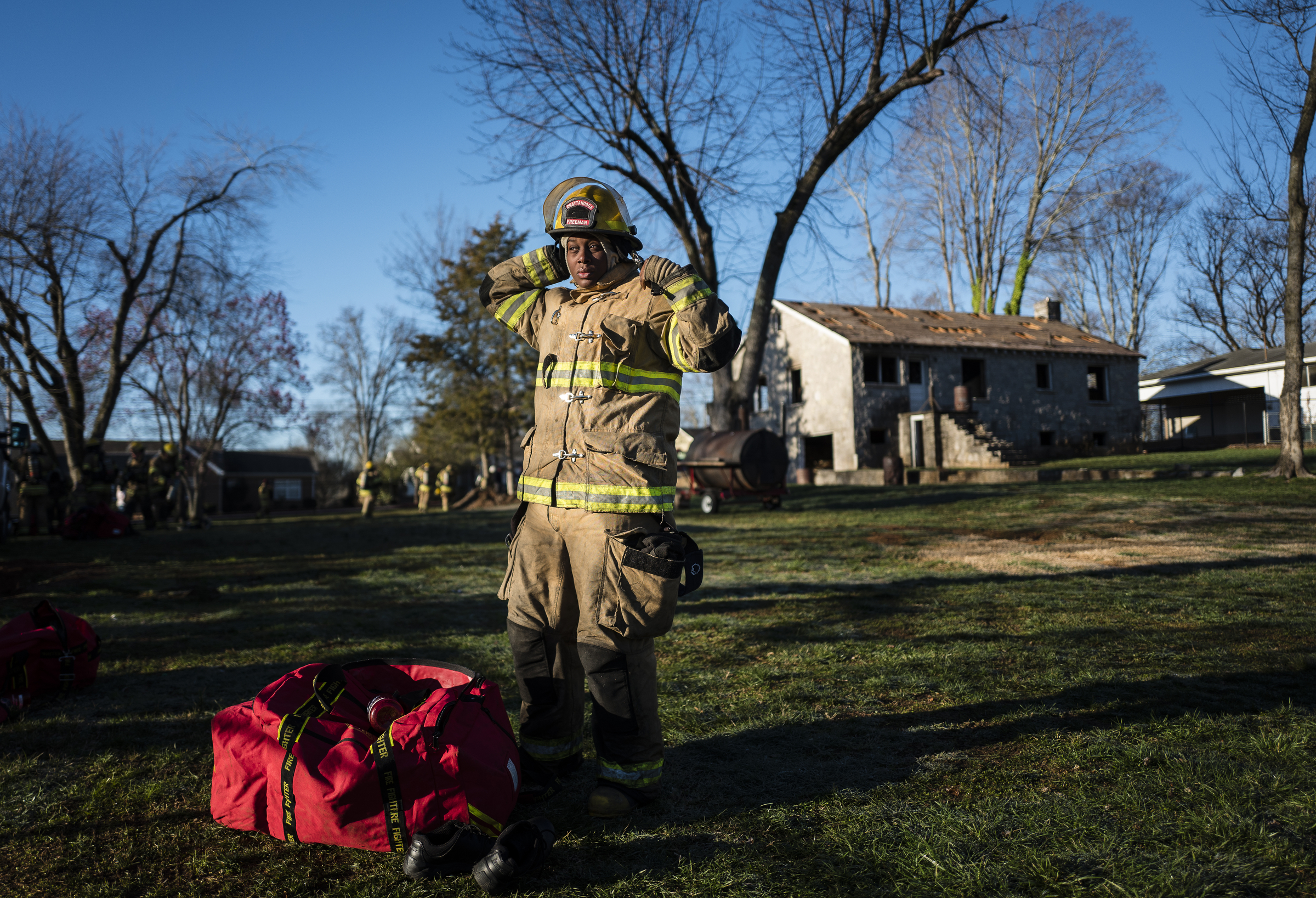 Fire recruit Shanika Freeman gears up at a live burn training event by the Chattanooga Fire Department on Robin Drive on Thursday, Feb. 16, 2017, in Chattanooga, Tenn. The fire department uses live burns as part of their fire academy training, culminating in the complete immolation of a structure.