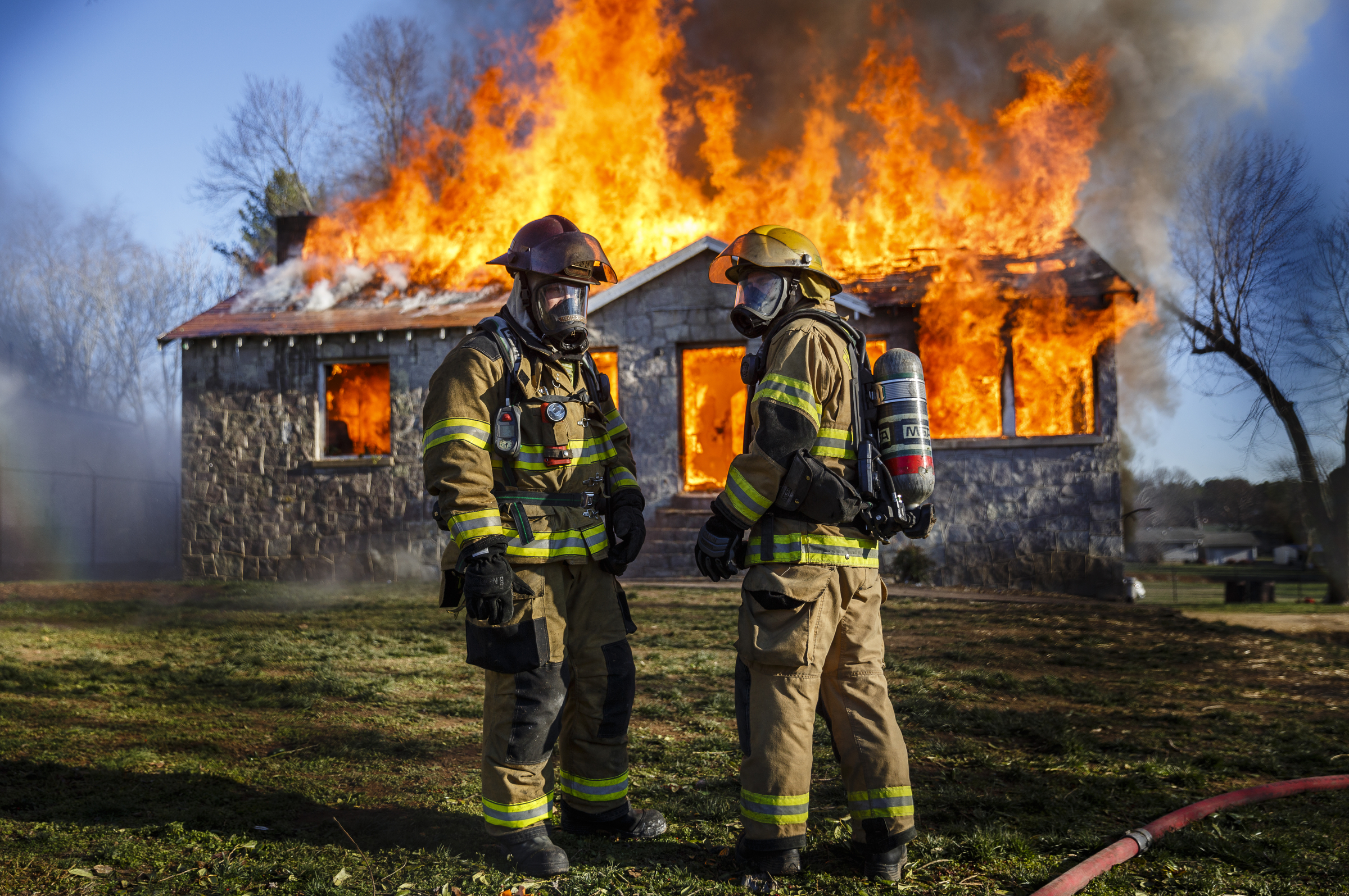 Firefighters stand in front of a fully engulfed structure at a live burn training event by the Chattanooga Fire Department on Robin Drive on Thursday, Feb. 16, 2017, in Chattanooga, Tenn. The fire department uses live burns as part of their fire academy training, culminating in the complete immolation of a structure.