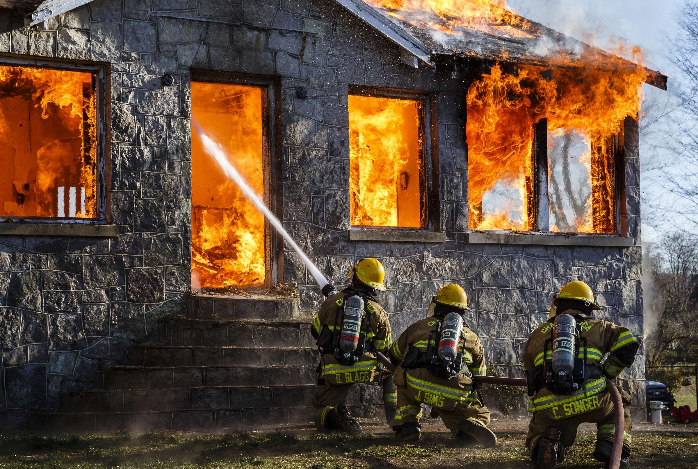 Firefighters spray a hose at the fully engulfed structure at a live burn training event by the Chattanooga Fire Department on Robin Drive on Thursday, Feb. 16, 2017, in Chattanooga, Tenn. The fire department uses live burns as part of their fire academy training, culminating in the complete immolation of a structure.