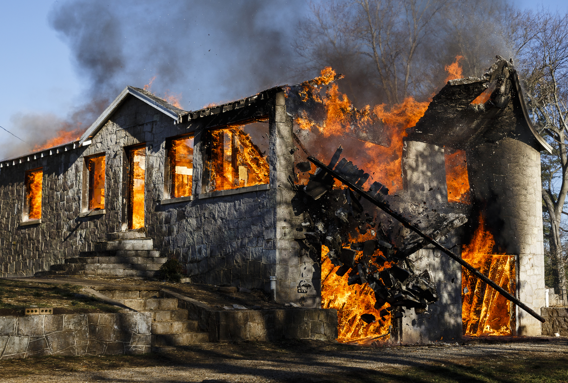One of the structure's walls collapses at a live burn training event by the Chattanooga Fire Department on Robin Drive on Thursday, Feb. 16, 2017, in Chattanooga, Tenn. The fire department uses live burns as part of their fire academy training, culminating in the complete immolation of a structure.
