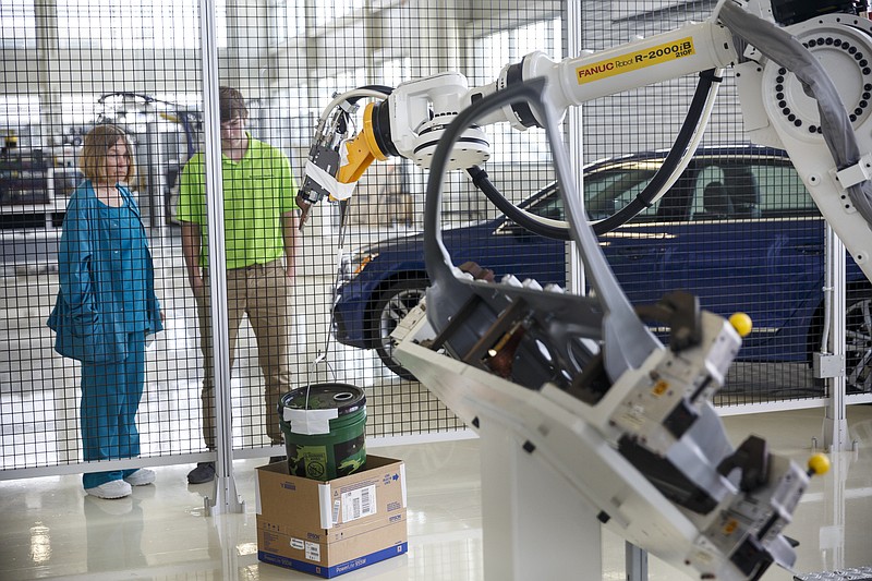 Staff file photo by Doug Strickland / Mechatronics student Cameron Newman, right, and Teresa White watch as another student operates a training robot at Chattanooga's Volkswagen manufacturing plant last summer. Last fall, 27 Hamilton County high school juniors enrolled in Volkswagen's new Mechatronics Akademie where they will learn how to run and maintain industrial robots.