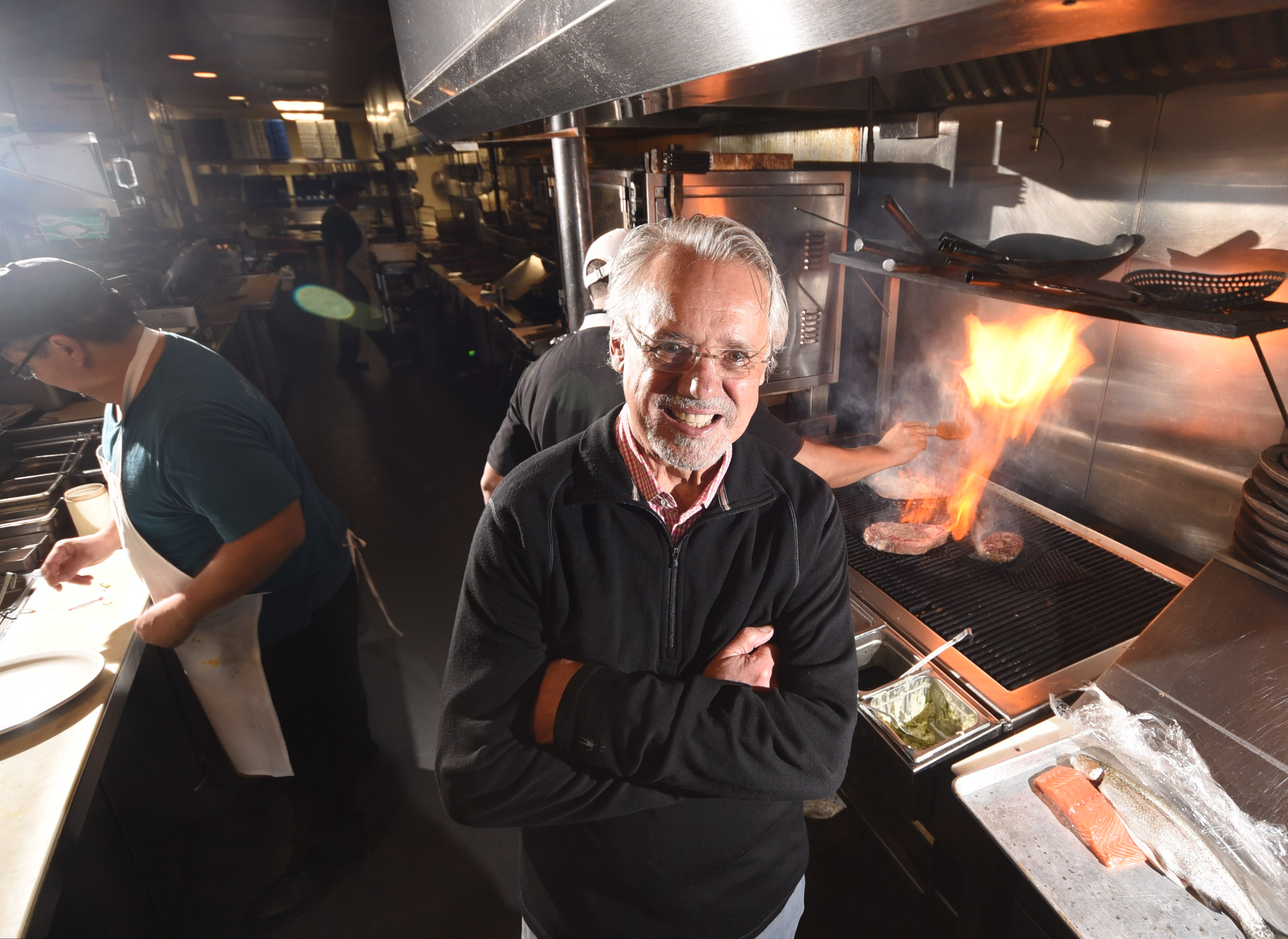 Lawton Haygood stands in front of one of his patented wood grills in the kitchen at the Boathouse Rotisserie & Raw Bar on Riverside Drive.
