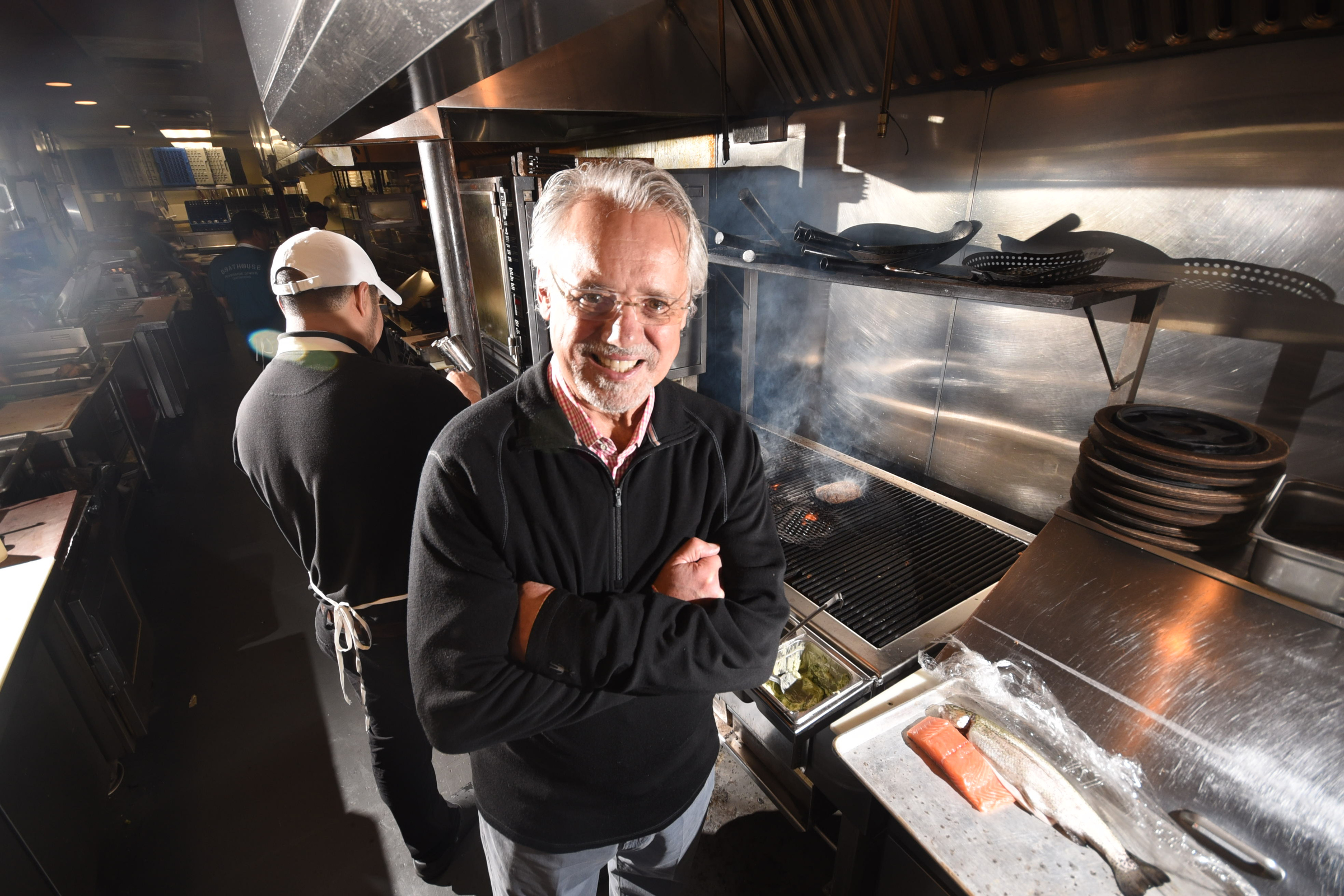 Lawton Haygood stands in front of one of his patented wood grills in the kitchen at the Boathouse Rotisserie & Raw Bar on Riverside Drive.