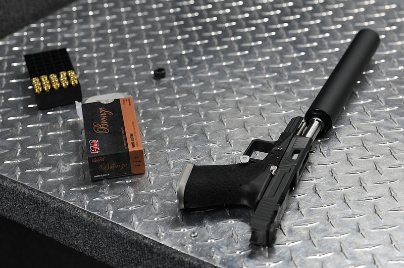 Staff Photo by Angela Lewis Foster A gun, silencer and bullets sit in the gun range at Shooters Depot on Shallowford Road.