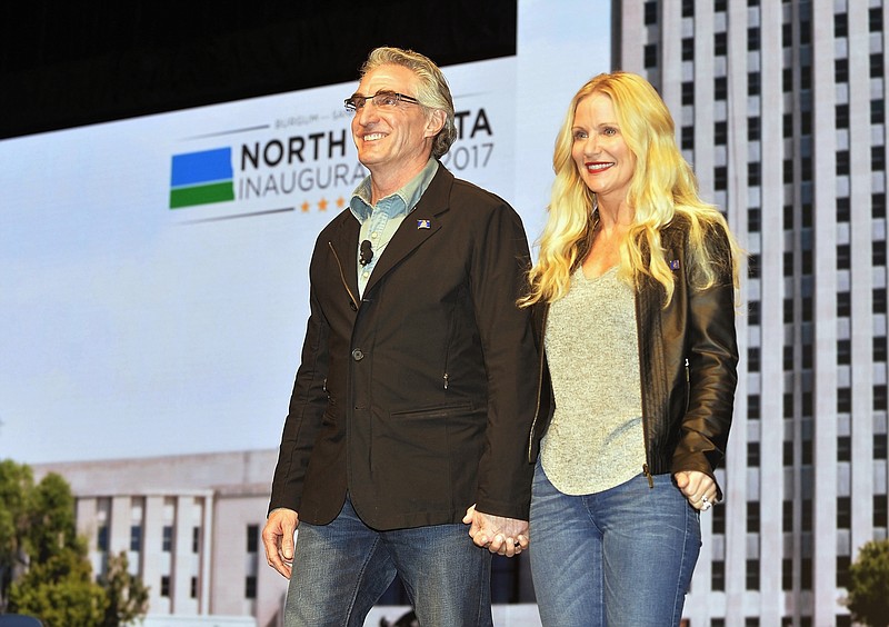 
              FILE - In this Jan. 4, 2017 photo, North Dakota Gov. Doug Burgum and first lady Kathryn Helgaas Burgum greet the crowd at the governor's inauguration celebration in Bismarck, N.D. Burgum's preference for wearing jeans got him booted from the North Dakota Senate floor Wednesday, Feb. 15, 2017, while he was posing for a photo with some high school students. A spokesman says the governor "meant no disrespect to the chamber rules." (Will Kincaid/The Bismarck Tribune via AP, File)/The Bismarck Tribune via AP)
            