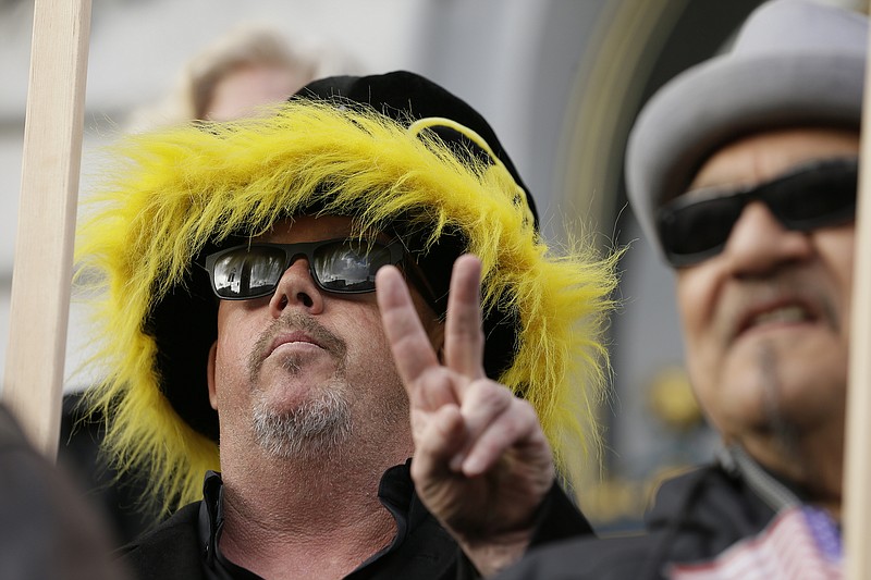 
              A man flashes a peace sign during a rally for a Summer of Love anniversary concert outside City Hall Thursday, Feb. 16, 2017, in San Francisco. The show might still go on but a concert planned to mark the 50th anniversary of the Summer of Love has hit another major bureaucratic hurdle. San Francisco's Recreation and Park Commission on Thursday upheld its decision earlier this month to deny a permit for the concert. (AP Photo/Eric Risberg)
            