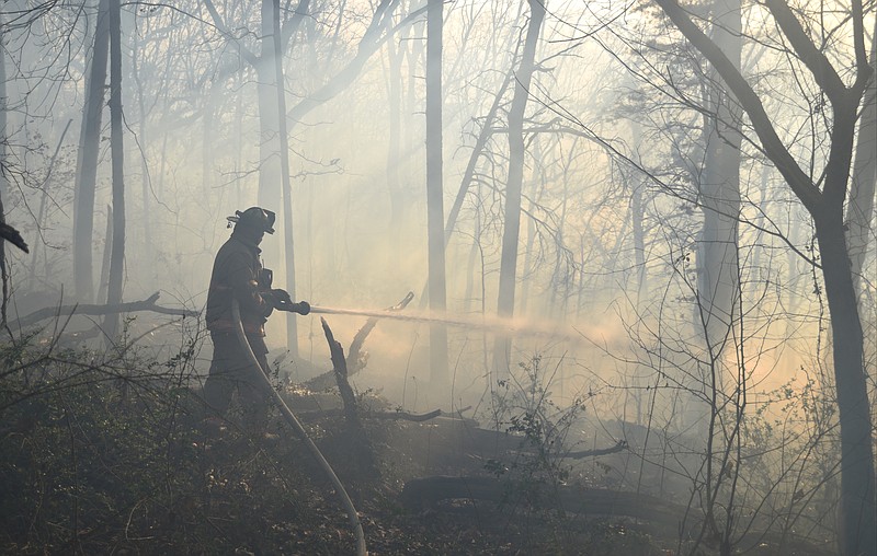 Johnny Stephens, with Rossville Fire Department, battles a brush fire off South Mission Ridge Drive in Rossville, Ga., Friday, Feb. 17, 2017.