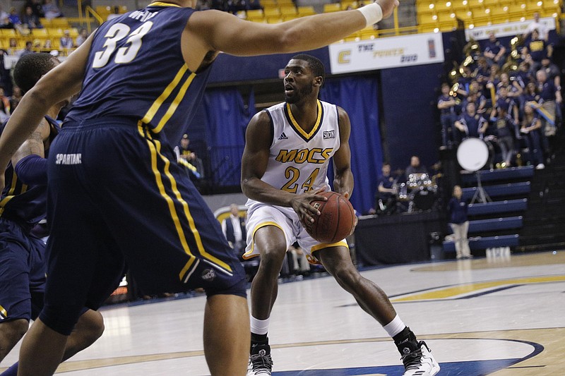 UTC fifth-year senior Casey Jones, right, shown looking to pass around UNC Greensboro center R.J. White on Feb. 2 in McKenzie Arena, has seen a lot of progess in the Mocs program since his arrival.