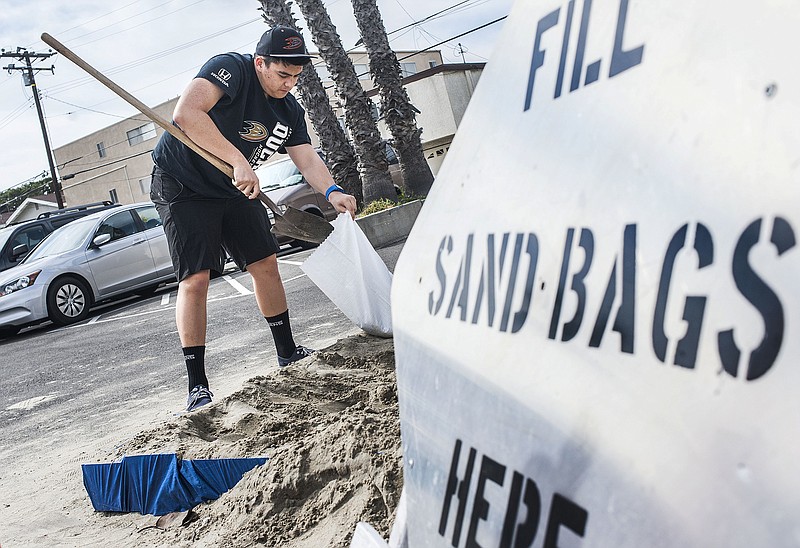 
              Chad Adriano fills up sand bags before the weekend storms at the Orange County Fire Authority Station 44 in downtown in Seal Beach, Calif., Thursday, Feb. 16, 2017. Wet weather returned to California on Thursday with the first in a new series of rainstorms moving across the northern half of the state while the south awaited a storm that forecasters said could be the strongest in years if not decades. (Nick Agro/The Orange County Register via AP)
            