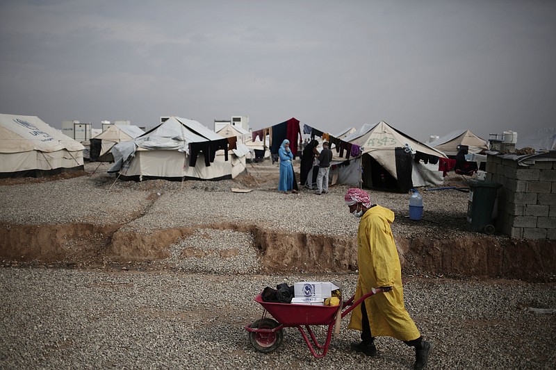 
              A worker carried aid supplied at a camp for people displaced by fighting between security forces and Islamic State militants east of Mosul, Iraq, Wednesday, Feb. 15, 2017. The United Nations says they are temporarily pausing aid operations to neighborhoods in eastern Mosul retaken from the Islamic State group for security reasons as IS insurgent and counter attacks continue to inflict heavy civilian casualties there.(AP Photo/Bram Janssen)
            