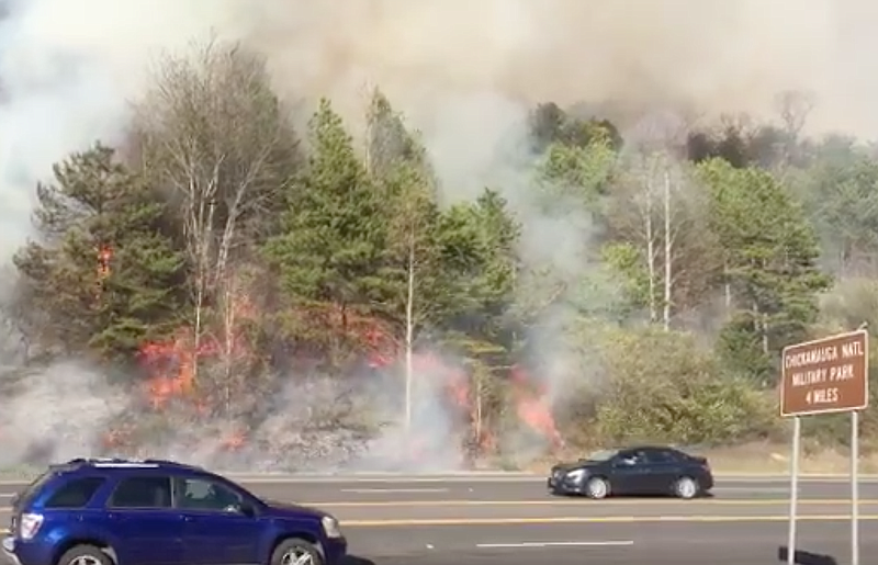 Screenshot of a video shows a fire burning alongside Battlefield Parkway. 