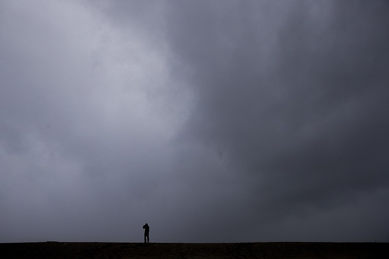 
              A man records high waves with his smartphone while standing on a sand berm Friday, Feb. 17, 2017, in Seal Beach, Calif. A powerful Pacific storm blew into southern and central California on Friday, unleashing wind-driven heavy rains. (AP Photo/Jae C. Hong)
            