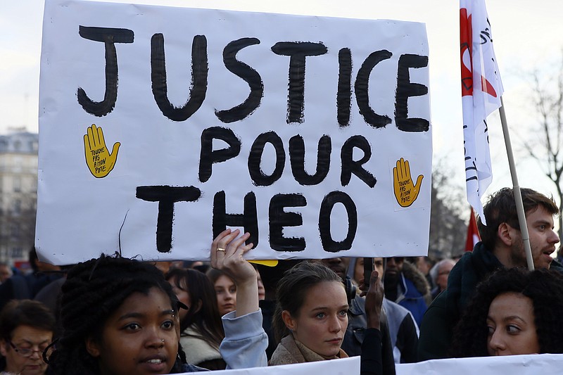 
              Demontrators hold a placard reading "Justice for Theo" during a protest against alleged police abuse, in Paris Saturday, Feb. 18, 2017. Anti-racism groups and other activists are gathered in Paris in support of victims of police violence, after a young black man was allegedly raped with a police baton in an incident that prompted violent protests in impoverished suburbs. (AP Photo/Francois Mori)
            