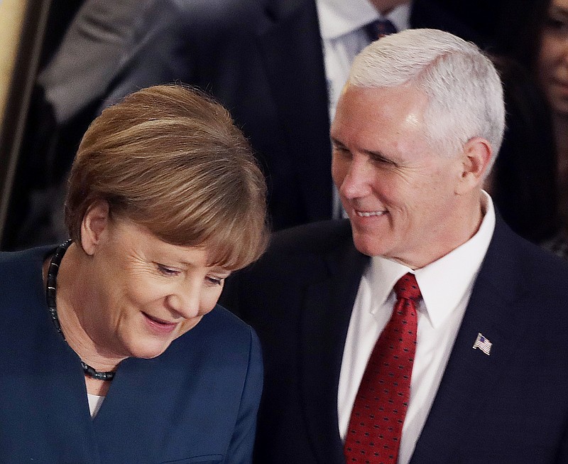 German Chancellor Angela Merkel, left, and United States Vice President Mike Pence arrive at the Munich Security Conference in Munich, Germany, Saturday, Feb. 18, 2017. The annual weekend gathering is known for providing an open and informal platform to meet in close quarters. (AP Photo/Matthias Schrader)